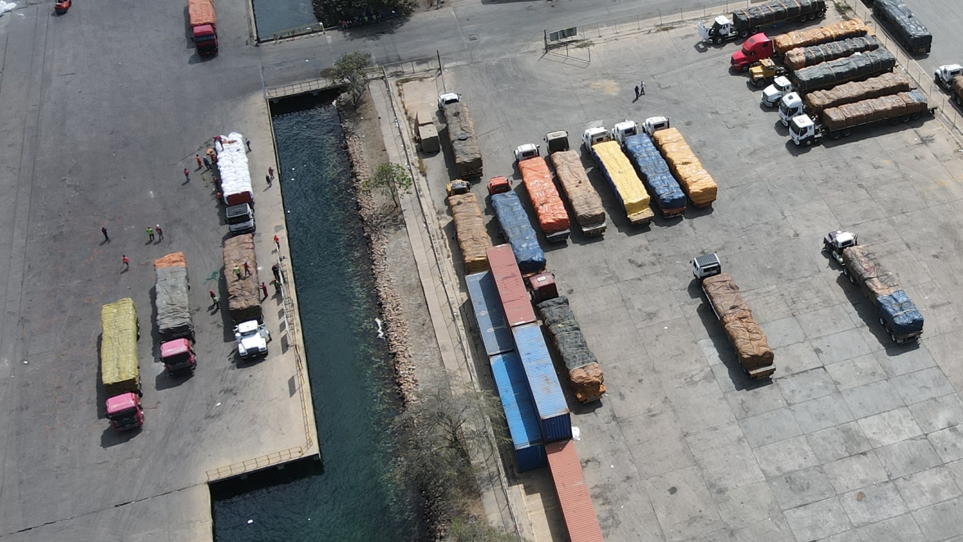 Vista aérea de patio de camiones y contenedores cargados en el puerto